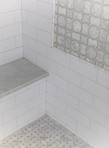 bathroom shower with marble mosaic accent
