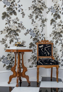 antique chair in piano room with floral wallpaper