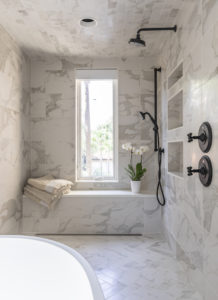 marble look tile and black plumbing fixtures in condo bathroom